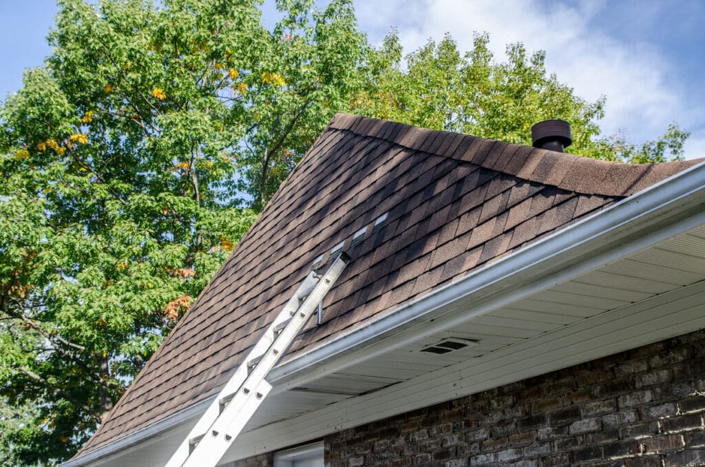 Échelle appuyée contre une toiture résidentielle pour inspection